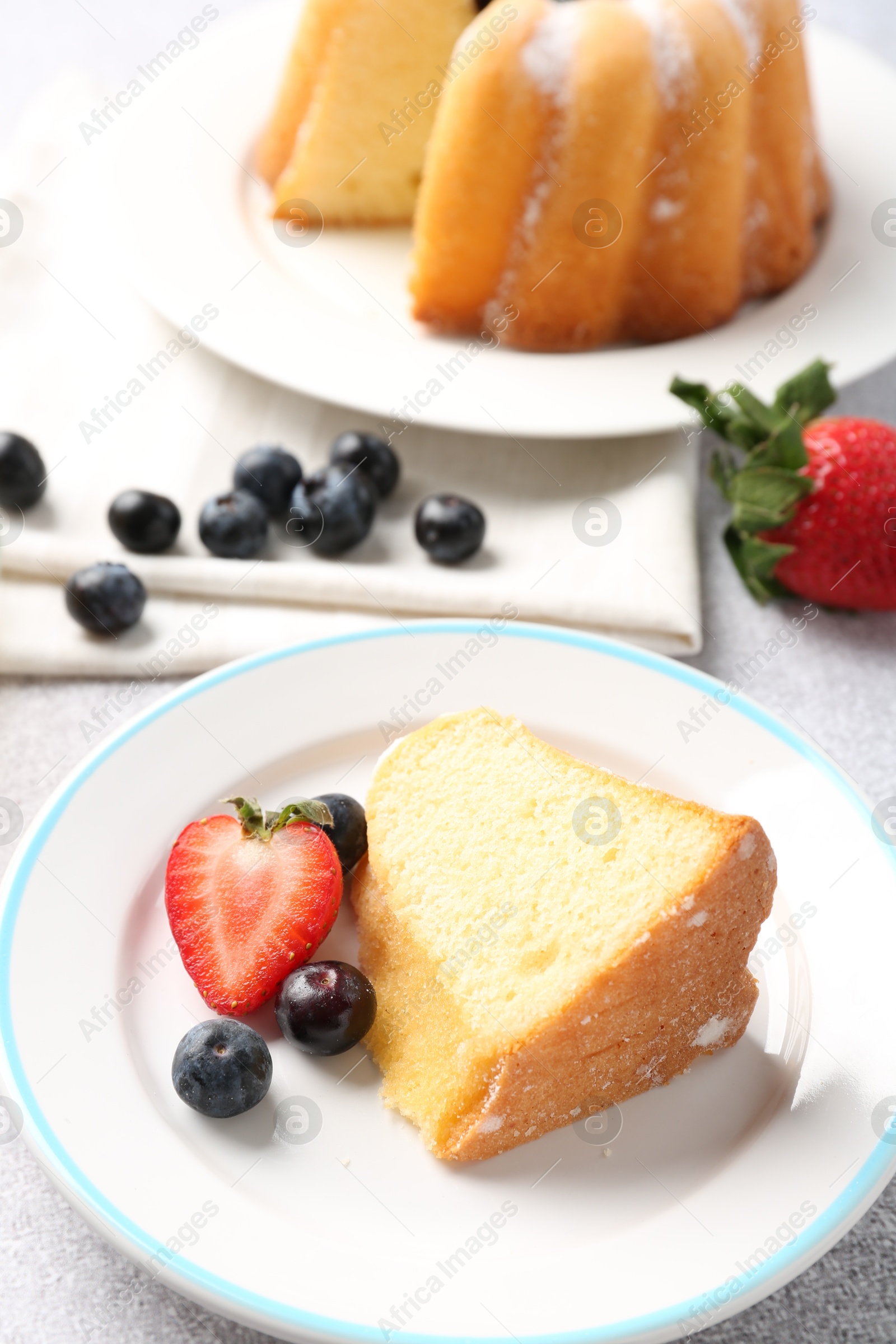 Piece of tasty bundt cake with berries on table, closeup Photo of Piece of tasty bundt cake with berries on table, closeup
