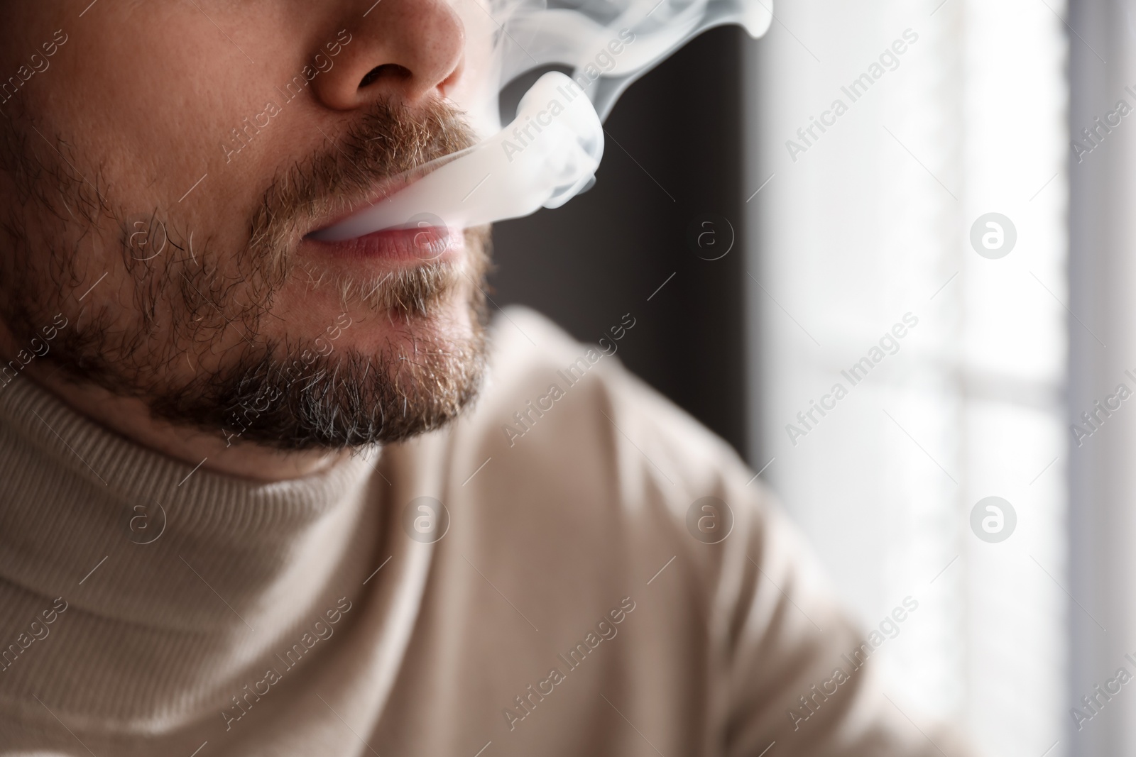 Man smoking cigarette on blurred background, closeup Photo of Man smoking cigarette on blurred background, closeup