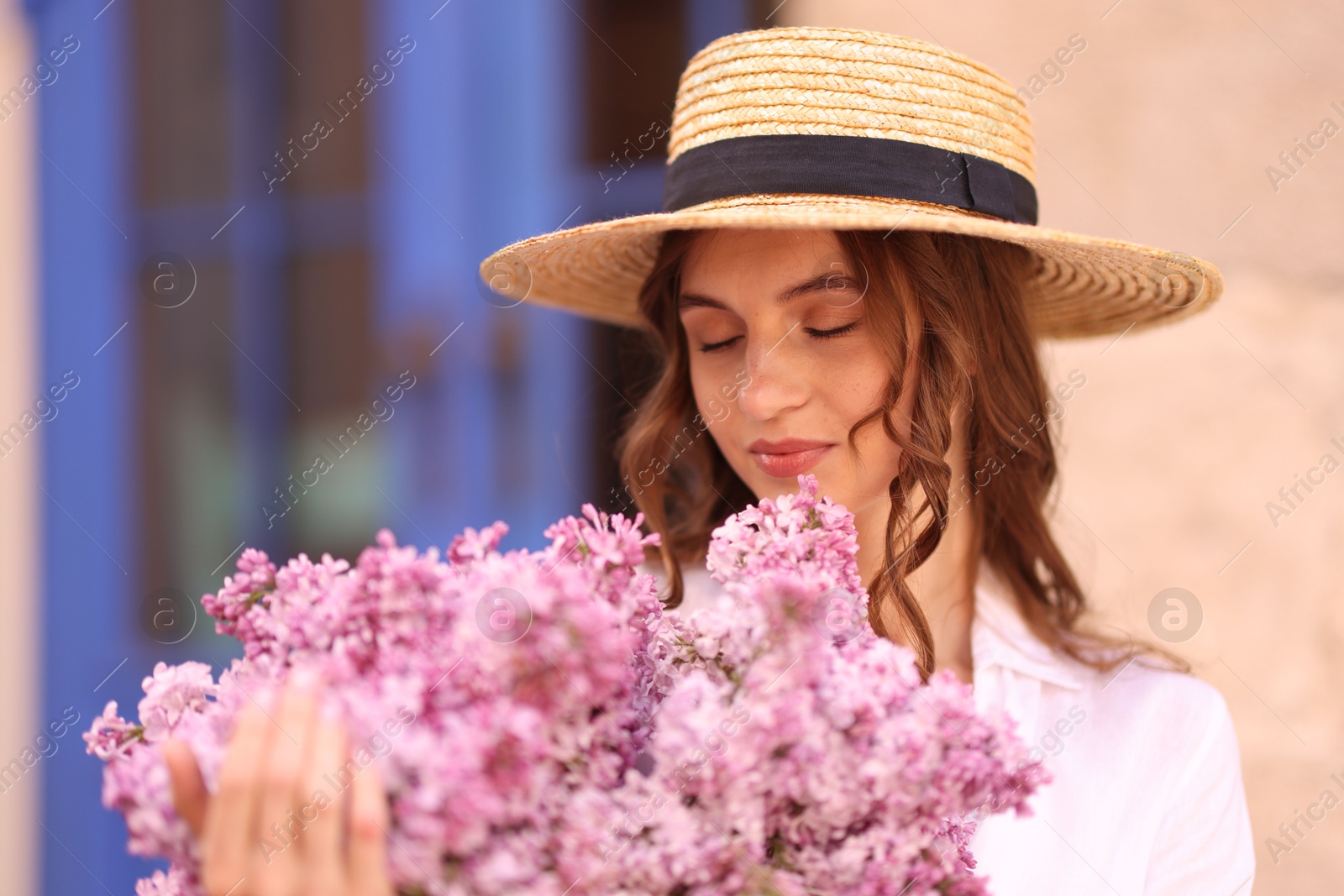 Beautiful woman in hat with bouquet of lilac flowers outdoors Photo of Beautiful woman in hat with bouquet of lilac flowers outdoors