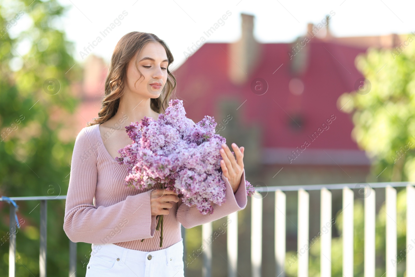 Beautiful woman with bouquet of lilac flowers outdoors in morning. Space for text Photo of Beautiful woman with bouquet of lilac flowers outdoors in morning. Space for text