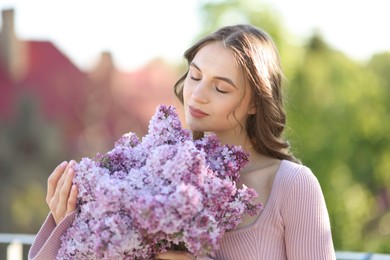 Photo of Beautiful woman with bouquet of lilac flowers outdoors in morning