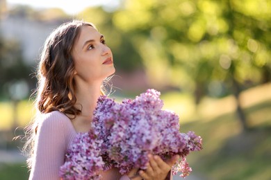 Photo of Beautiful woman with bouquet of lilac flowers outdoors in morning