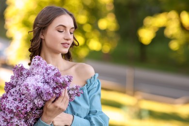 Photo of Smiling woman with bouquet of lilac flowers outdoors in morning. Space for text
