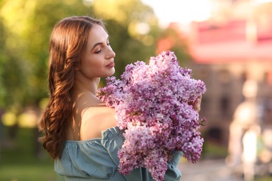 Photo of Beautiful woman with bouquet of lilac flowers outdoors in morning