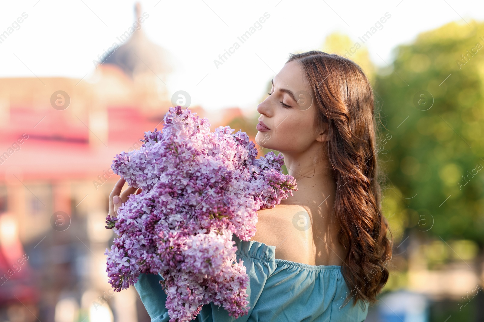 Beautiful woman with bouquet of lilac flowers outdoors in morning Photo of Beautiful woman with bouquet of lilac flowers outdoors in morning