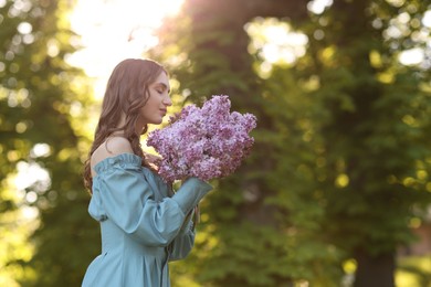 Photo of Beautiful woman with bouquet of lilac flowers outdoors in morning. Space for text