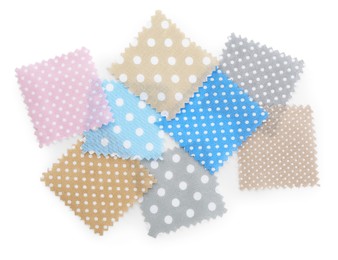 Photo of Samples of fabrics with polka dot pattern isolated on white, top view
