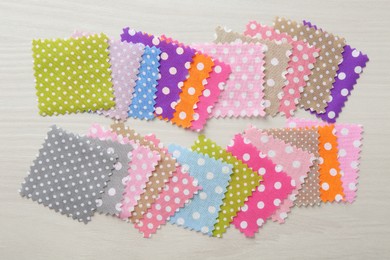 Photo of Samples of different fabrics on white wooden table, flat lay