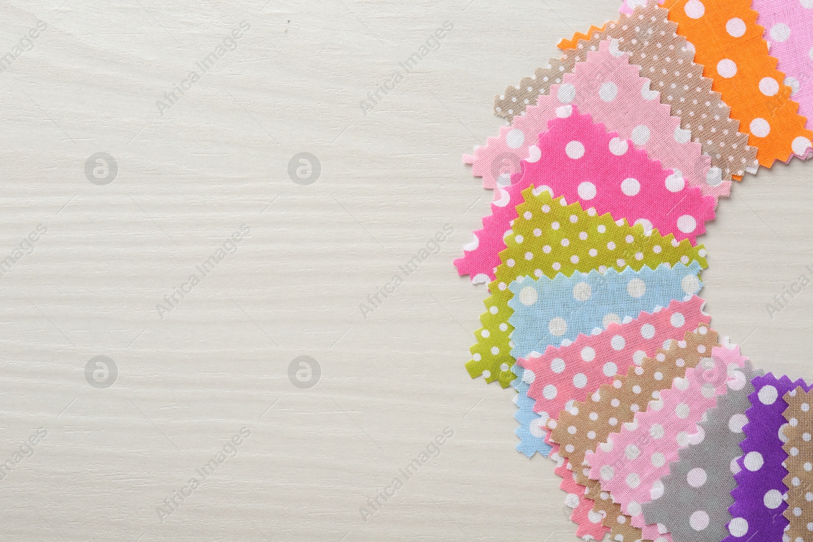 Samples of different fabrics on white wooden table, flat lay. Space for text Photo of Samples of different fabrics on white wooden table, flat lay. Space for text