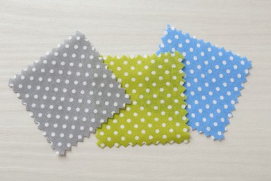 Photo of Samples of different fabrics on white wooden table, flat lay