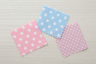 Photo of Samples of different fabrics on white wooden table, flat lay