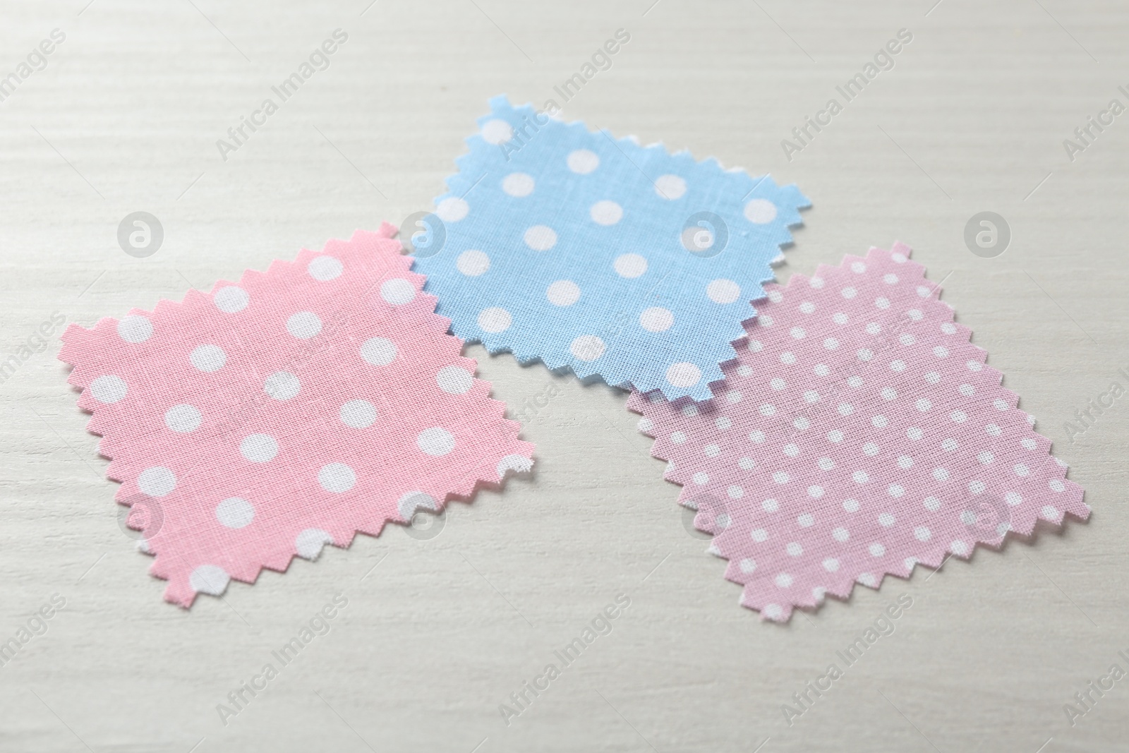 Samples of different fabrics on white wooden table, closeup Photo of Samples of different fabrics on white wooden table, closeup