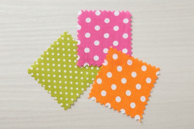 Photo of Samples of different fabrics on white wooden table, flat lay