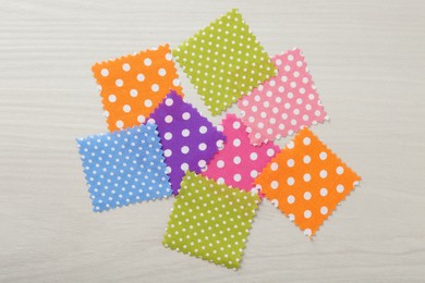 Photo of Samples of different fabrics on white wooden table, flat lay
