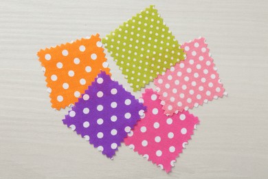 Photo of Samples of different fabrics on white wooden table, flat lay