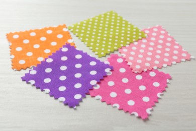 Photo of Samples of different fabrics on white wooden table, closeup