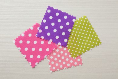Photo of Samples of different fabrics on white wooden table, flat lay