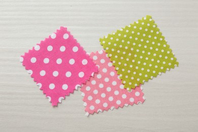 Photo of Samples of different fabrics on white wooden table, flat lay