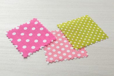 Photo of Samples of different fabrics on white wooden table, closeup