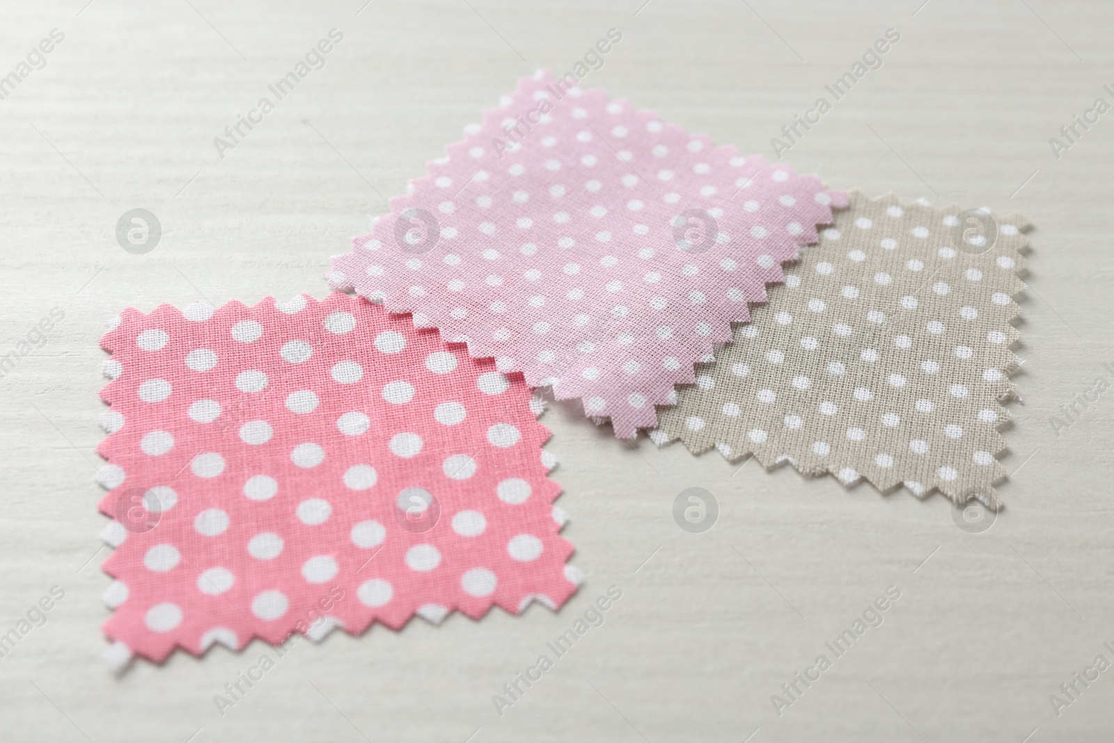 Samples of different fabrics on white wooden table, closeup Photo of Samples of different fabrics on white wooden table, closeup