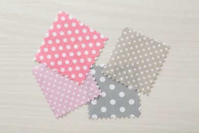 Photo of Samples of different fabrics on white wooden table, flat lay