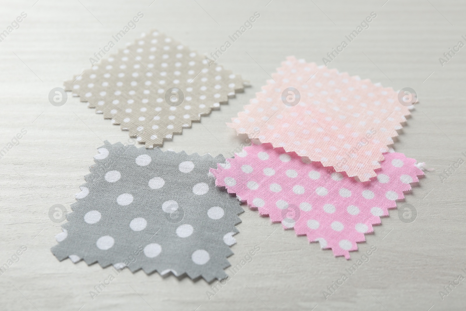 Samples of different fabrics on white wooden table, closeup Photo of Samples of different fabrics on white wooden table, closeup