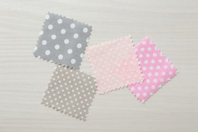 Photo of Samples of different fabrics on white wooden table, flat lay