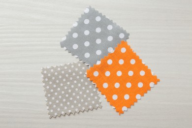 Photo of Samples of different fabrics on white wooden table, flat lay
