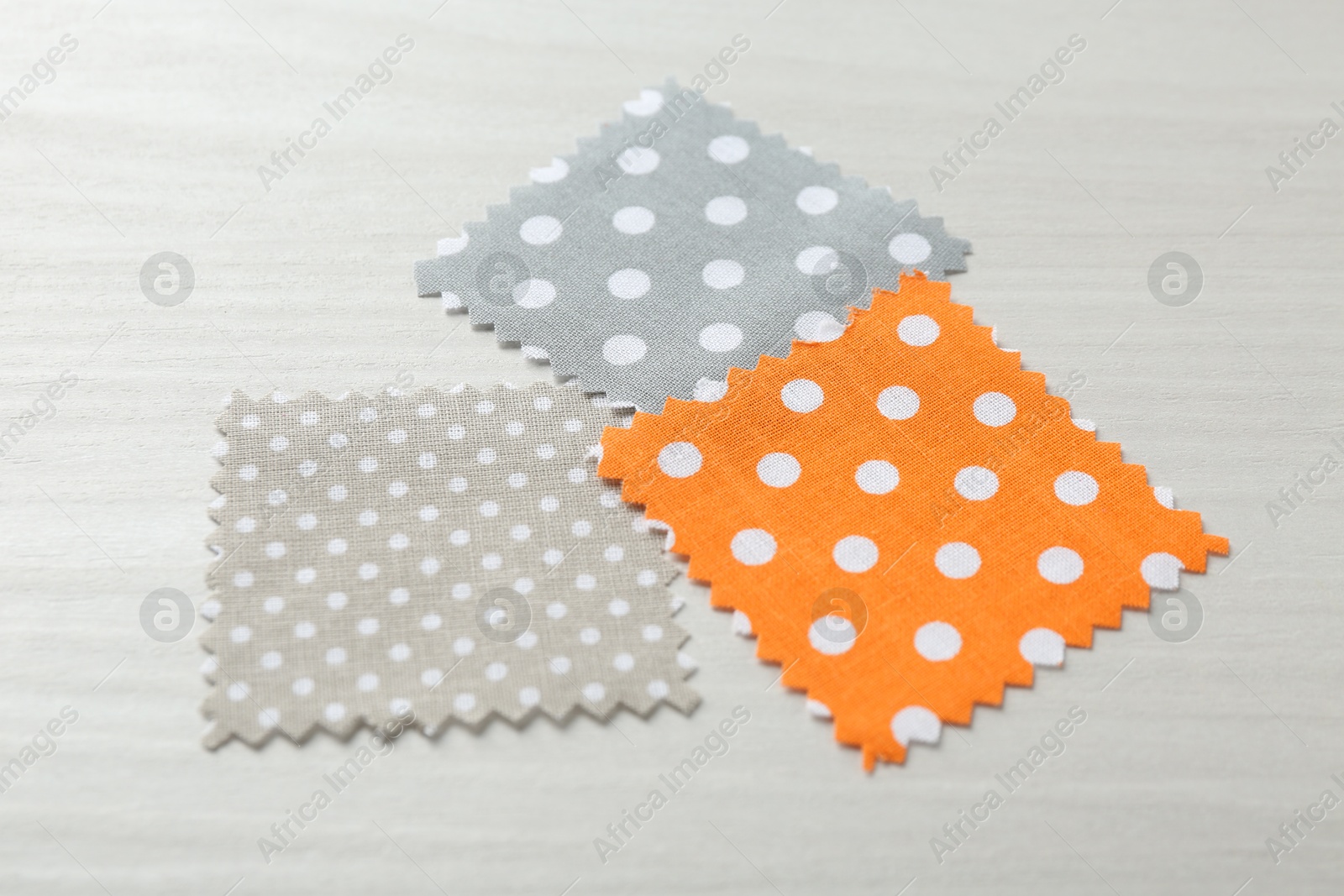 Samples of different fabrics on white wooden table, closeup Photo of Samples of different fabrics on white wooden table, closeup