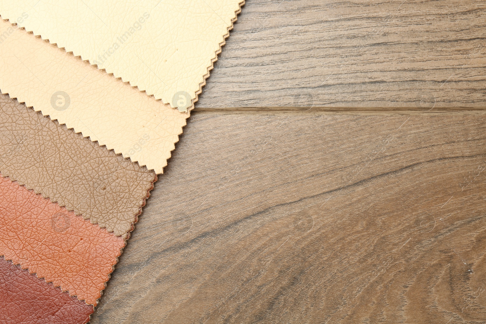 Samples of different fabrics on wooden table, top view. Space for text Photo of Samples of different fabrics on wooden table, top view. Space for text