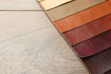Photo of Samples of different fabrics on wooden table, closeup. Space for text