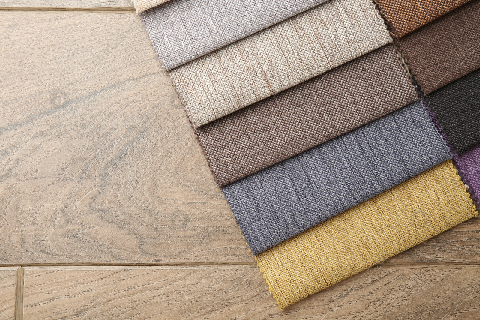 Samples of different fabrics on wooden table, top view. Space for text Photo of Samples of different fabrics on wooden table, top view. Space for text