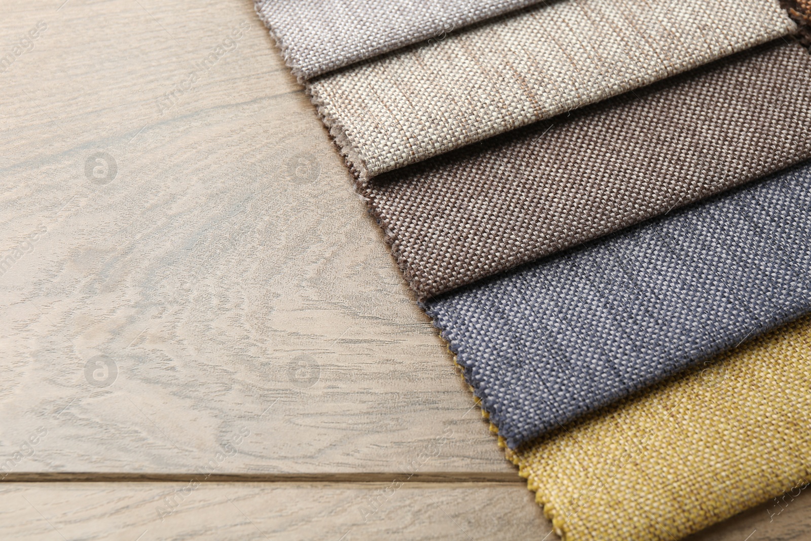 Samples of different fabrics on wooden table, closeup. Space for text Photo of Samples of different fabrics on wooden table, closeup. Space for text