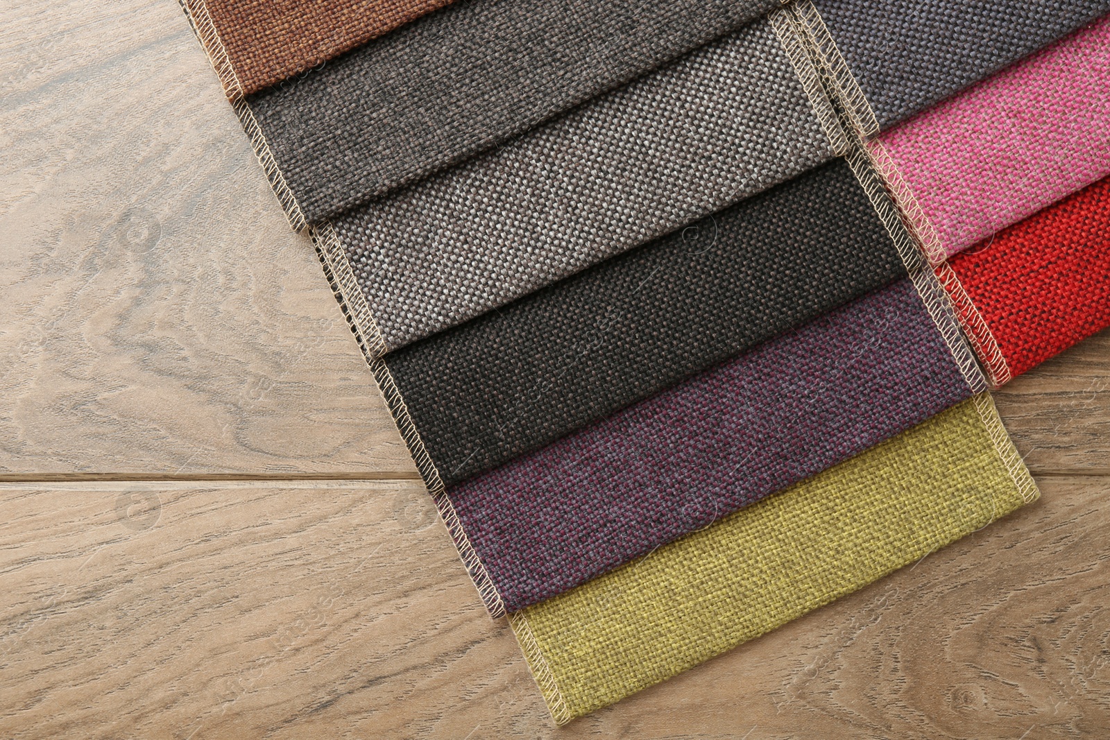 Samples of different fabrics on wooden table, top view Photo of Samples of different fabrics on wooden table, top view
