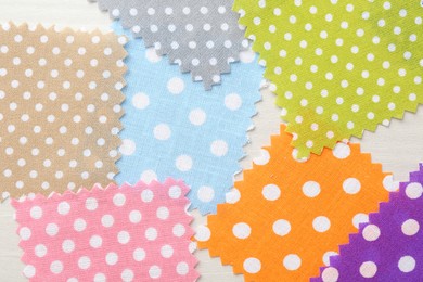 Photo of Samples of different fabrics on white wooden table, flat lay
