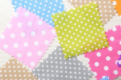Photo of Samples of different fabrics on white wooden table, flat lay