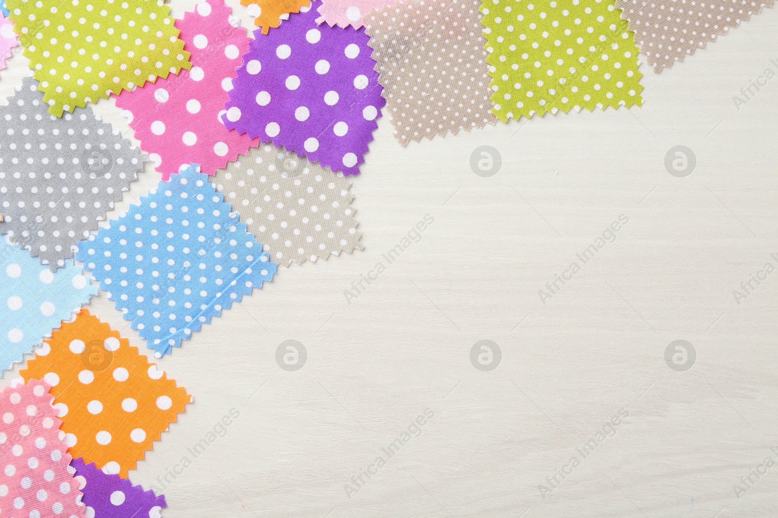 Samples of different fabrics on white wooden table, flat lay. Space for text Photo of Samples of different fabrics on white wooden table, flat lay. Space for text