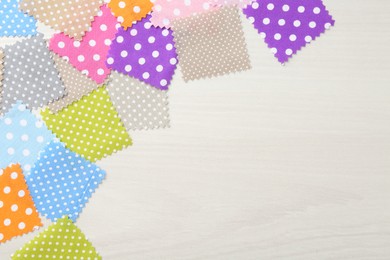 Photo of Samples of different fabrics on white wooden table, flat lay. Space for text