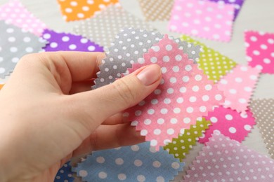 Photo of Woman with samples of different fabrics on white wooden table, closeup