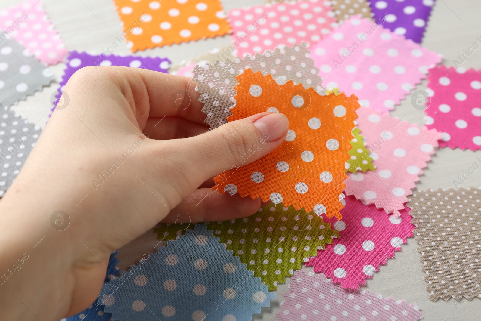 Woman with samples of different fabrics on white wooden table, closeup Photo of Woman with samples of different fabrics on white wooden table, closeup