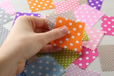 Photo of Woman with samples of different fabrics on white wooden table, closeup
