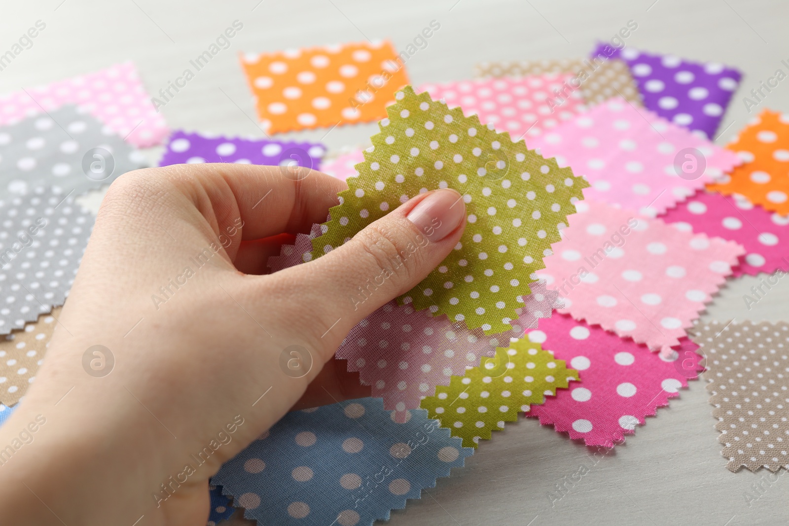 Woman with samples of different fabrics on white wooden table, closeup Photo of Woman with samples of different fabrics on white wooden table, closeup