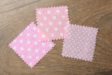 Photo of Samples of different fabrics on wooden table, flat lay