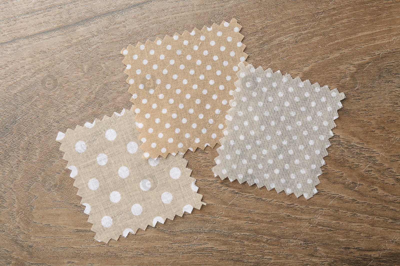 Samples of different fabrics on wooden table, flat lay Photo of Samples of different fabrics on wooden table, flat lay