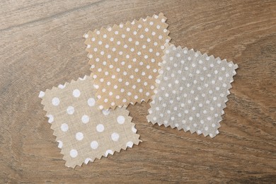 Photo of Samples of different fabrics on wooden table, flat lay
