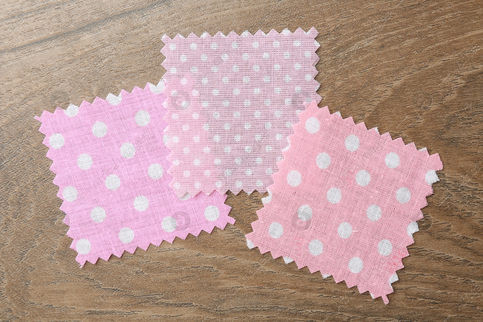 Samples of different fabrics on wooden table, flat lay Photo of Samples of different fabrics on wooden table, flat lay