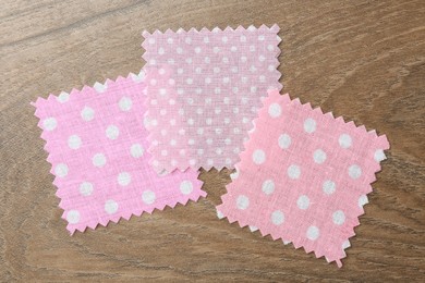 Photo of Samples of different fabrics on wooden table, flat lay
