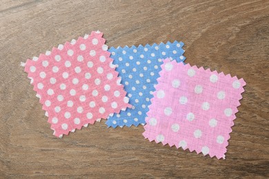Photo of Samples of different fabrics on wooden table, flat lay