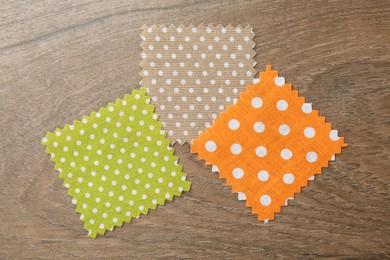 Photo of Samples of different fabrics on wooden table, flat lay