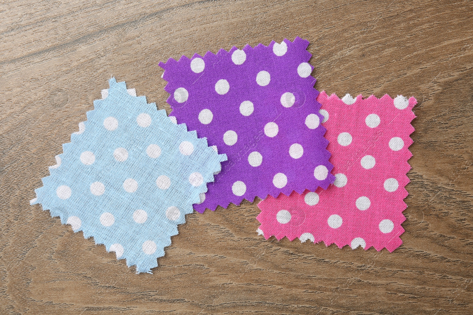 Samples of different fabrics on wooden table, flat lay Photo of Samples of different fabrics on wooden table, flat lay